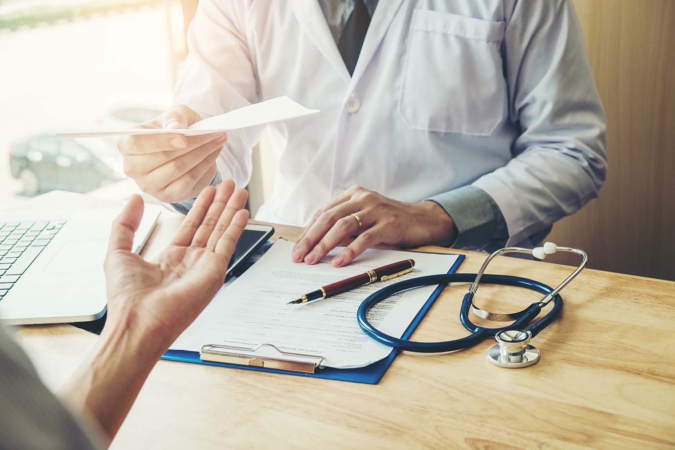 En øjenlæge giver en recept eller prescription til en patient. Brillerecept.