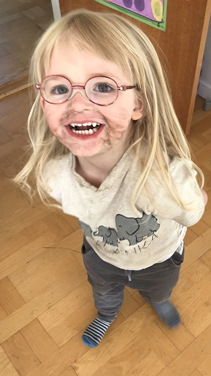 En glad pige med briller.